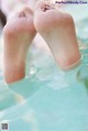 A pair of feet in a pool of water.