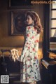 A woman standing in front of a piano in a room.