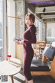 a woman in a red dress standing next to a table