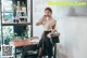 a woman sitting at a table in front of a whiteboard