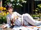 A woman in a white kimono laying on the ground.