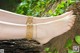 A woman wearing a pair of barefoot sandals on a tree trunk.