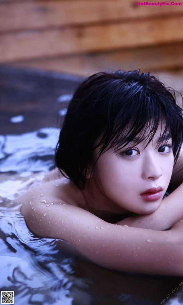 A young woman laying in a pool of water.