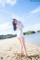 A woman standing on top of a sandy beach next to the ocean.