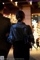 A man and a woman walking down a street at night.