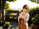 A woman in a kimono standing in a garden.