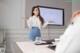 A woman standing in front of a projector screen giving a presentation.