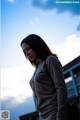 A woman standing in front of a blue sky.