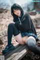 A woman sitting on a wooden bench in a park.