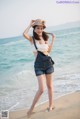 A woman standing on a beach next to the ocean.