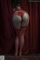 A woman in a red lingerie and fishnet stockings.