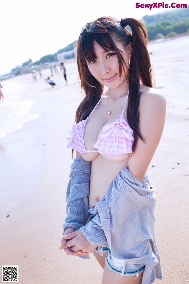 A woman in a pink bikini standing on a beach.