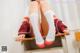 A woman sitting on top of a desk with her legs crossed.